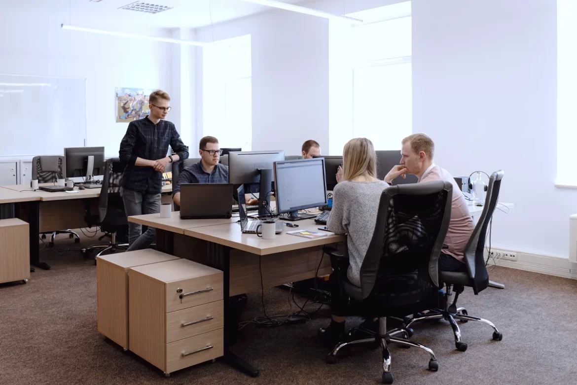 Grupo de pessoas trabalhando na frente de computadores mostrando como a automação é essencial